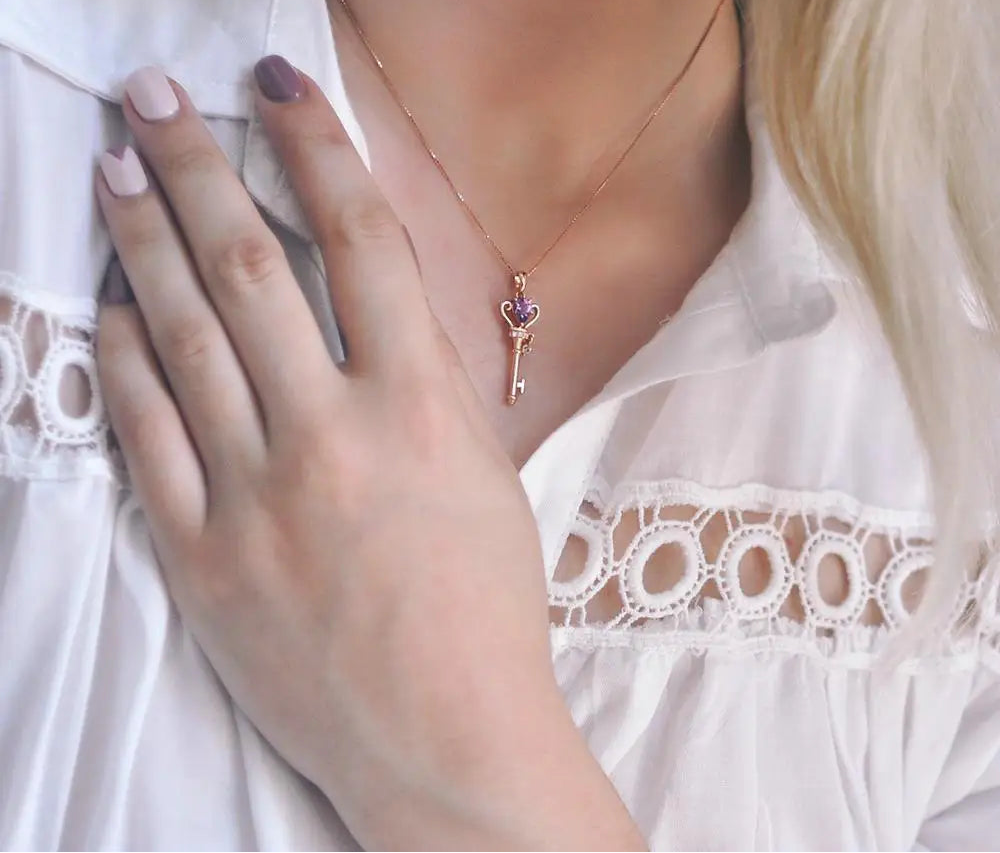 Necklace with a key pendant worn by a person.