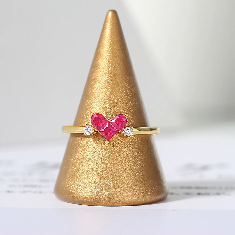 Ember red corundum heart ring displayed on a gold ring stand