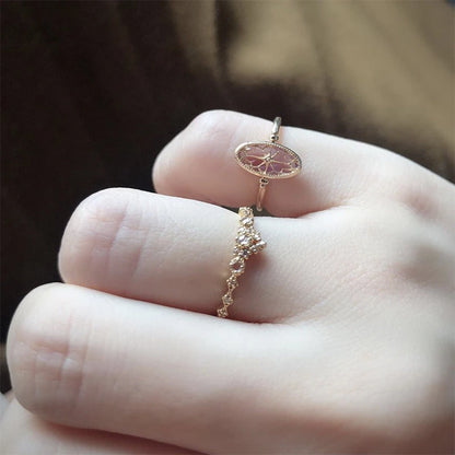 Two gold rings on a person's finger with a blurred background