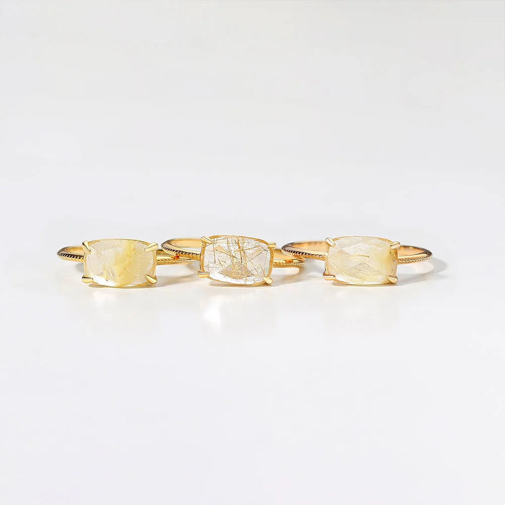Three gold rings on a light gray background
