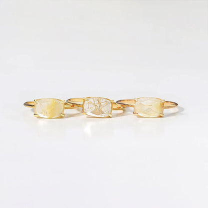 Three gold rings on a light gray background