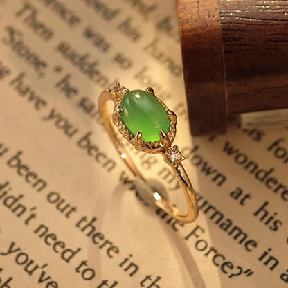 Green chalcedony ring with oval stone on a book and glasses