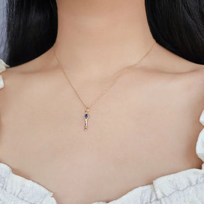 Blue corundum key pendant necklace worn on a model