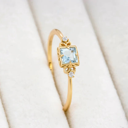 Side view of aquamarine ring with square gemstone and zircon accents