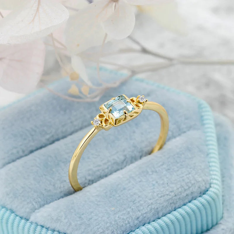 Aquamarine ring with zircon side stones on blue fabric