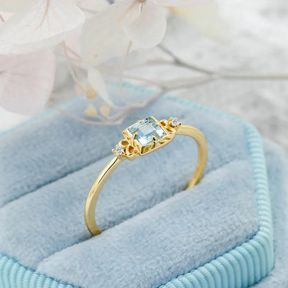 Aquamarine ring with zircon side stones on blue fabric