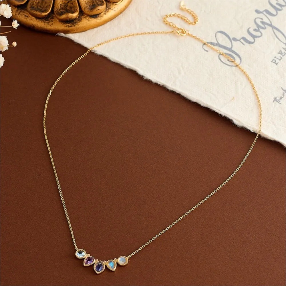 Gold necklace with colorful stones on a brown surface