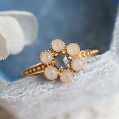 Natural iolite and agate flower ring displayed on soft floral background