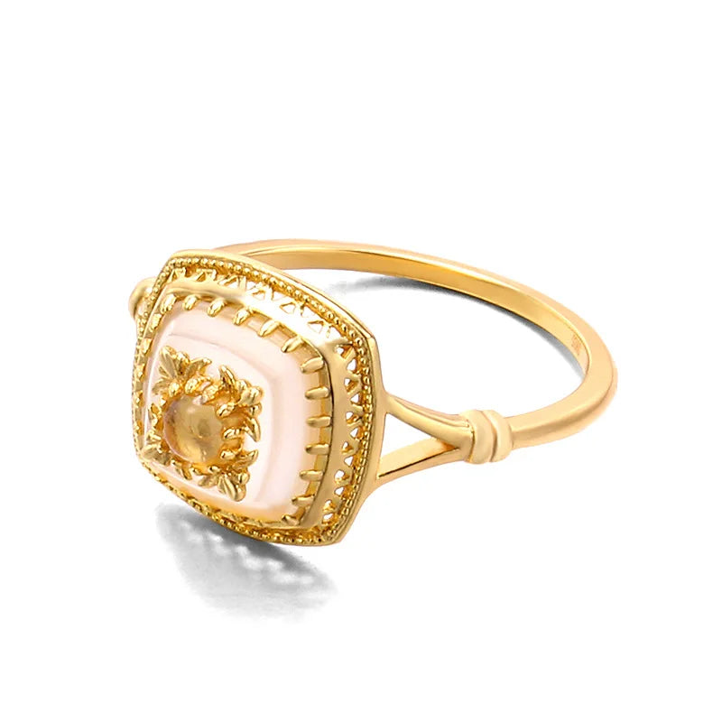 Gold ring with intricate design on a white background