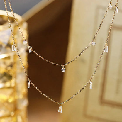 Gold necklace with small pendants on a blurred background,