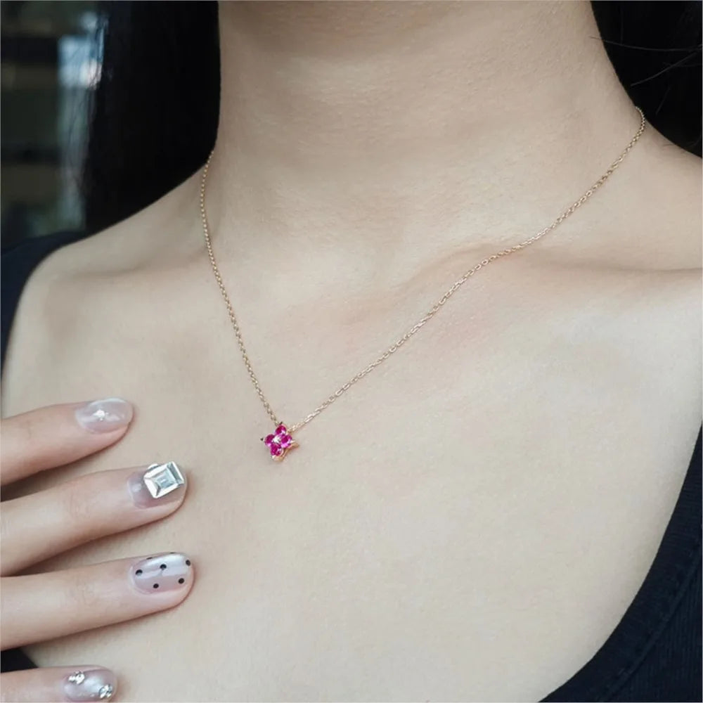 Ruby four-leaf clover necklace worn on a woman