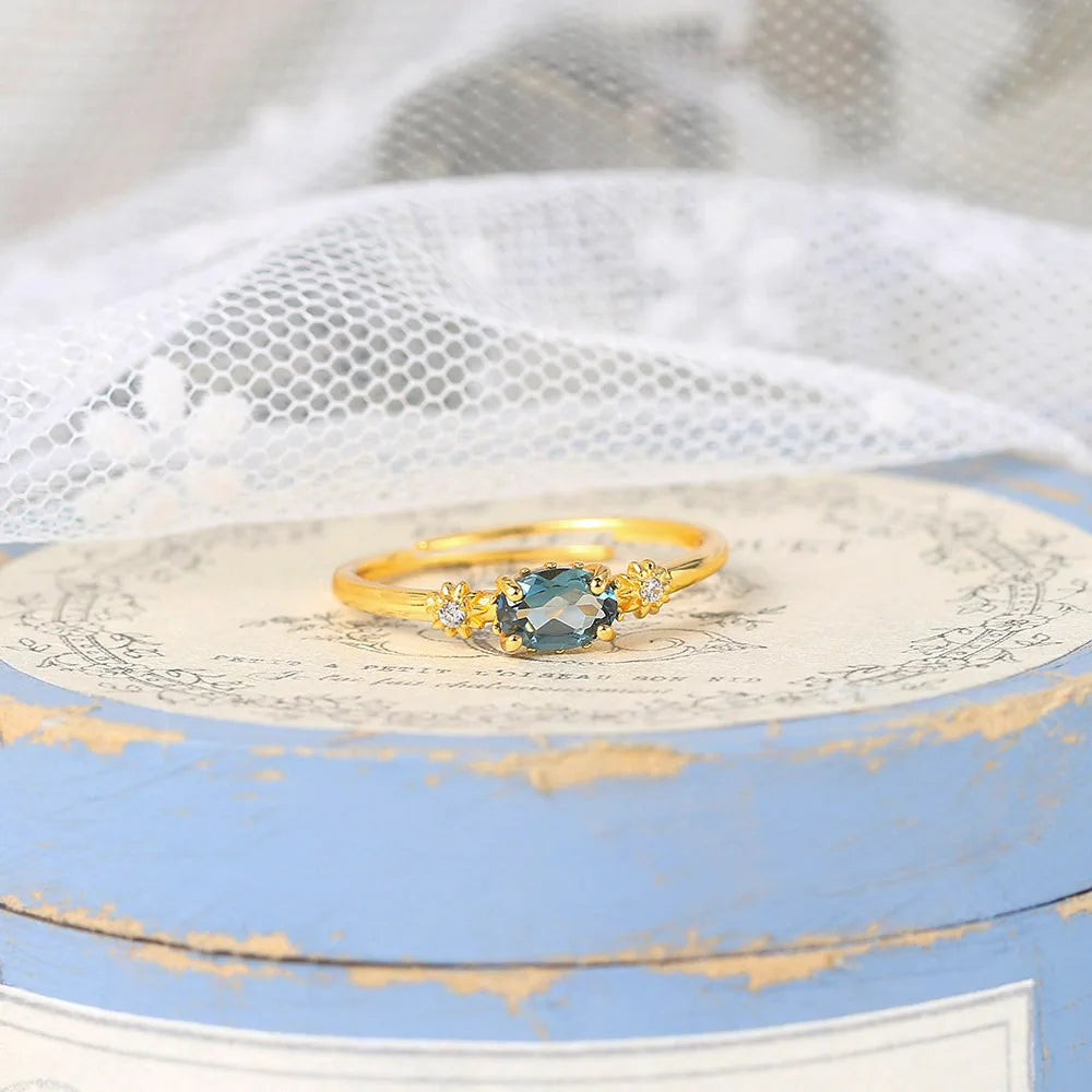 Gold ring with a blue blue gemstone on a decorative box