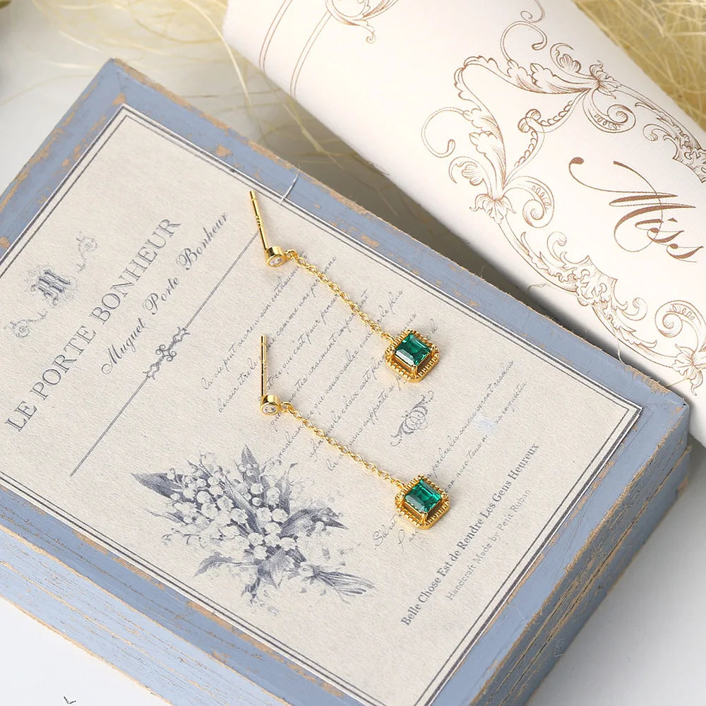 Lab-created emerald drop earrings displayed in jewelry box