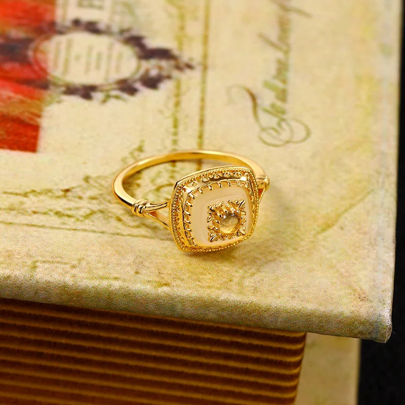 Gold vermeil chalcedony ring with detailed vintage setting on a decorative book