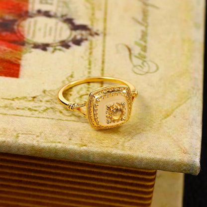 Gold vermeil chalcedony ring with detailed vintage setting on a decorative book