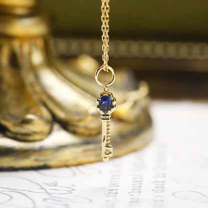 Close-up of blue corundum key pendant on 14K gold plated silver chain